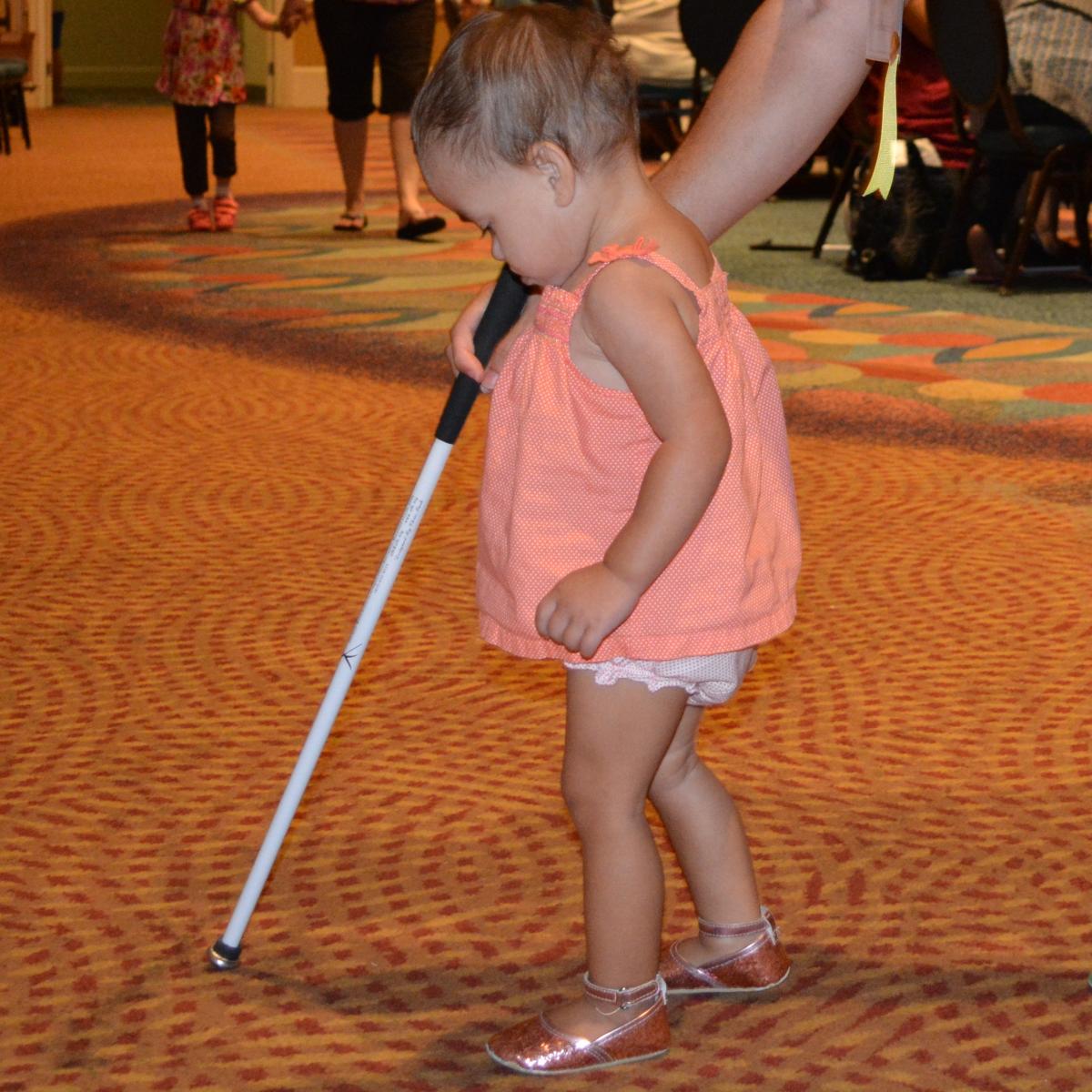 toddler using long white cane